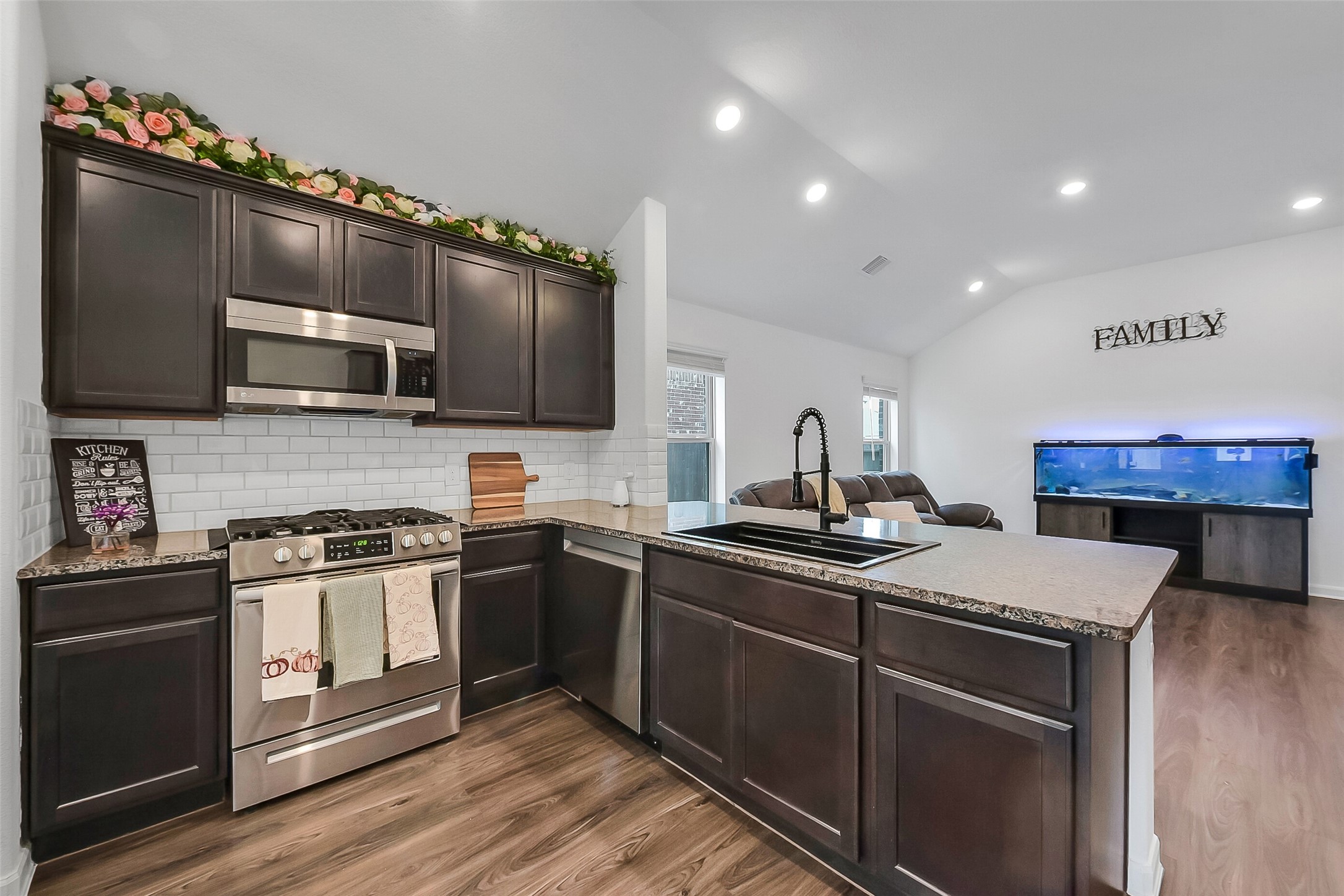 1004 Bulwark Crosby, TX 77532 - Photo 9 of 29 a kitchen with stainless steel appliances a sink dishwasher stove top oven and cabinets with wooden floor