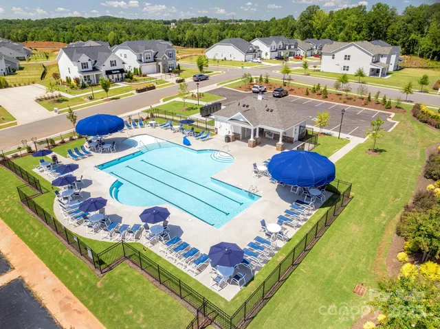 an aerial view of a swimming pool with outdoor seating