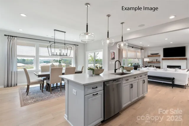 a kitchen with stainless steel appliances granite countertop a sink a stove and a wooden floors