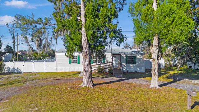 a view of a house with backyard and tree