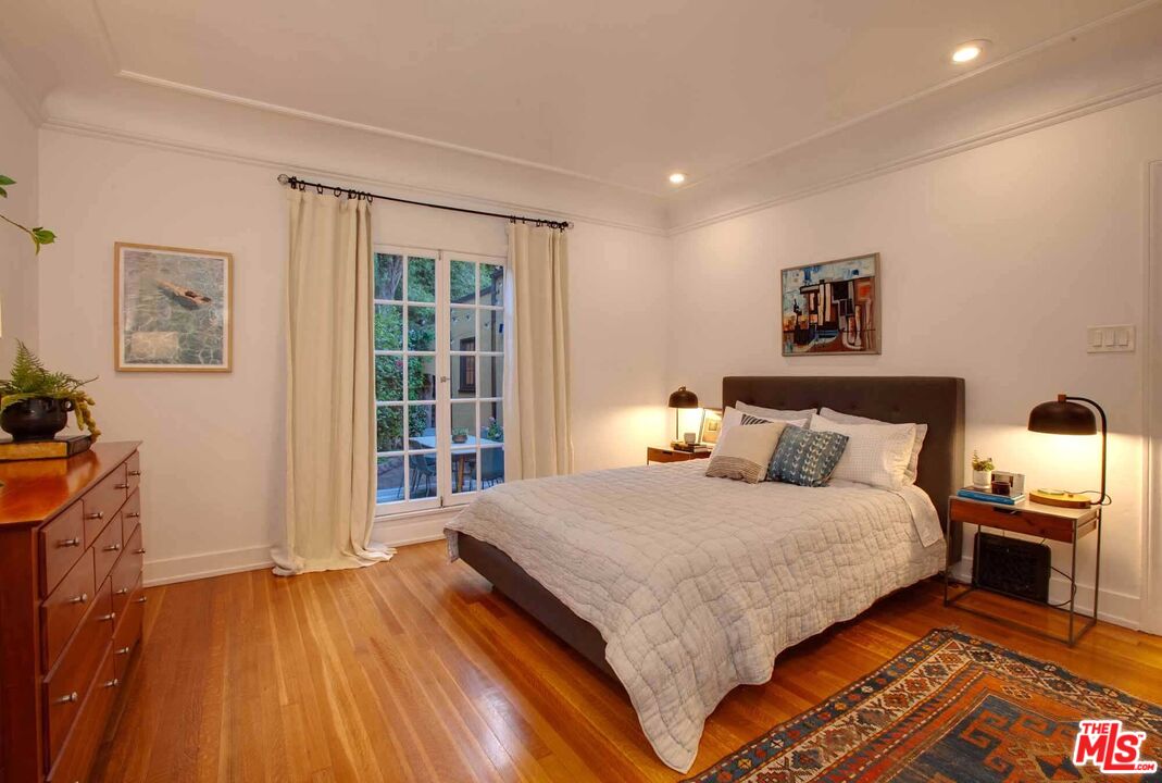 6354 Warner Drive Los Angeles, CA 90048 - Photo 25 of 43 a large bedroom with a bed and wooden floor