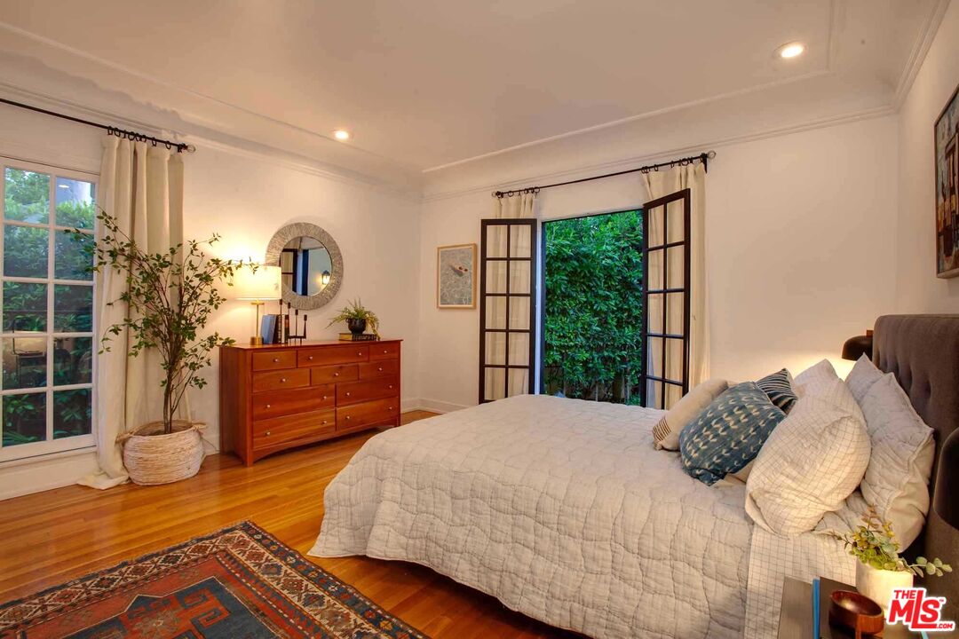 6354 Warner Drive Los Angeles, CA 90048 - Photo 26 of 43 a bedroom with a bed and wooden floor