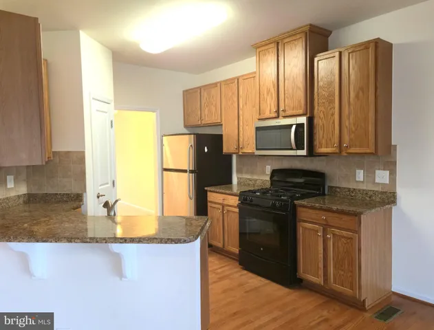 a kitchen with stainless steel appliances granite countertop a refrigerator stove microwave and sink