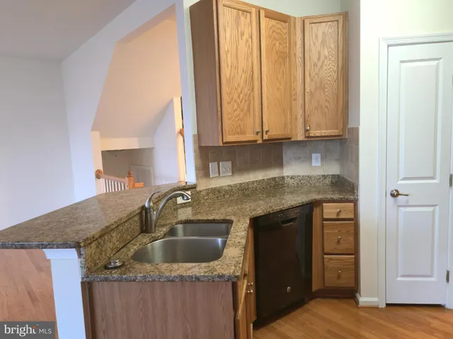 a kitchen with granite countertop a sink a stove and cabinets