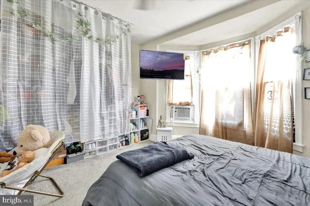 a bedroom with a bed and a large window