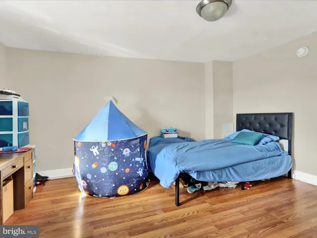 a bedroom with a bed and wooden floor