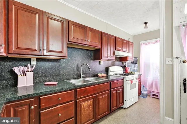 a kitchen with stainless steel appliances granite countertop a sink stove and cabinets