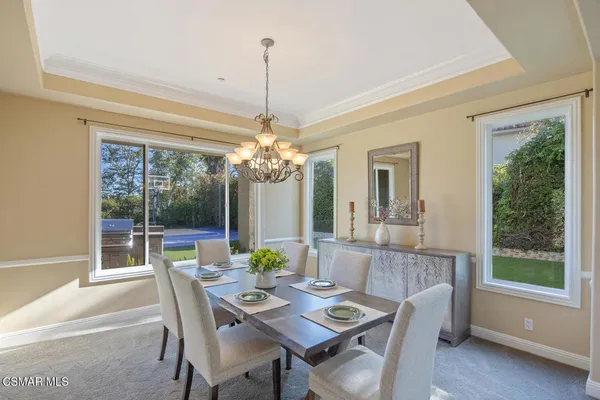 a view of a dining room and livingroom with furniture wooden floor a chandelier