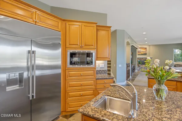 a bathroom with a granite countertop sink a toilet a mirror and shower