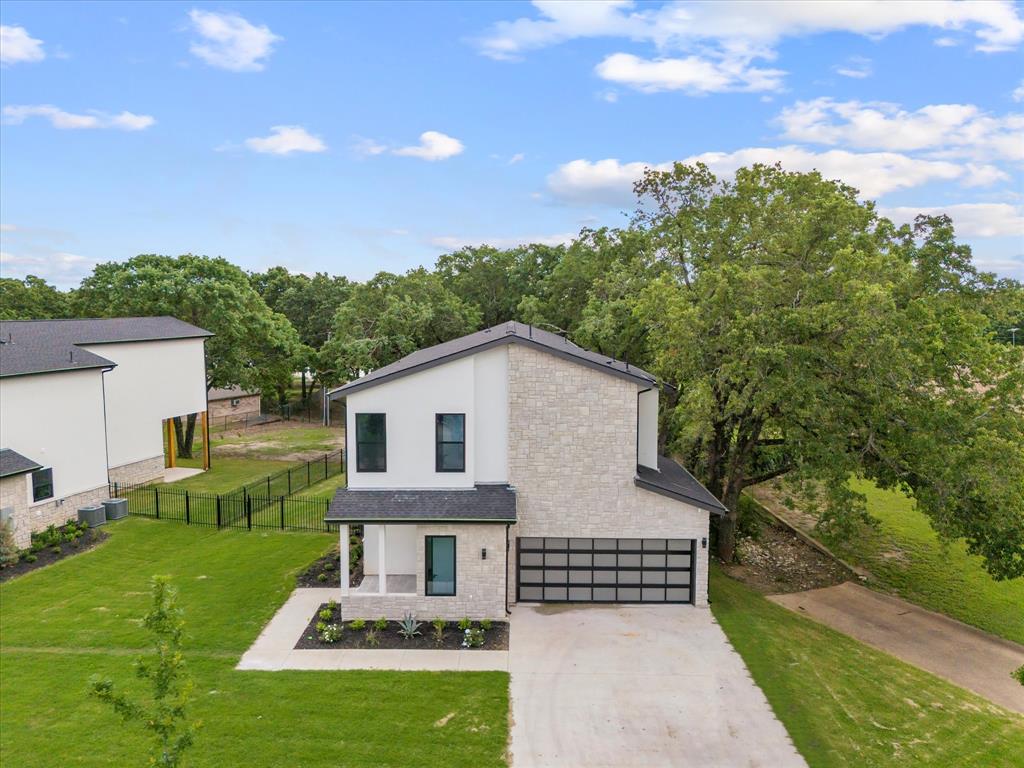 2811 Rodeo Drive Quinlan, TX 75474 - Photo 1 of 35 Contemporary home featuring a garage, driveway, roof with shingles, and stone siding