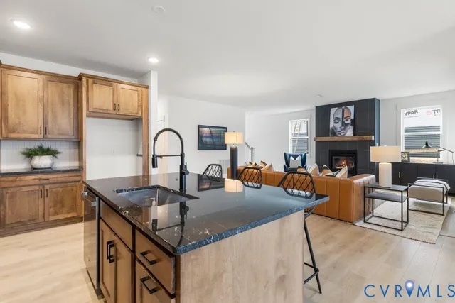 a kitchen with granite countertop a stove a sink a dining table and chairs