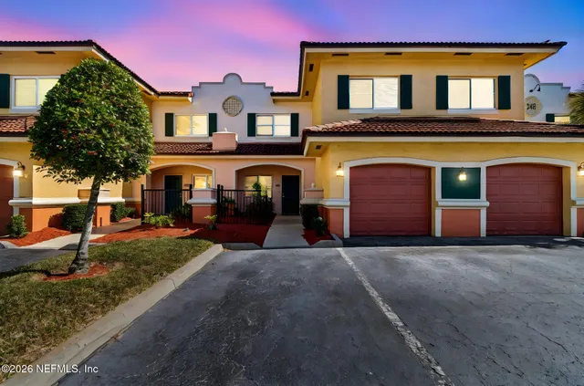 a front view of a house with yard and garage