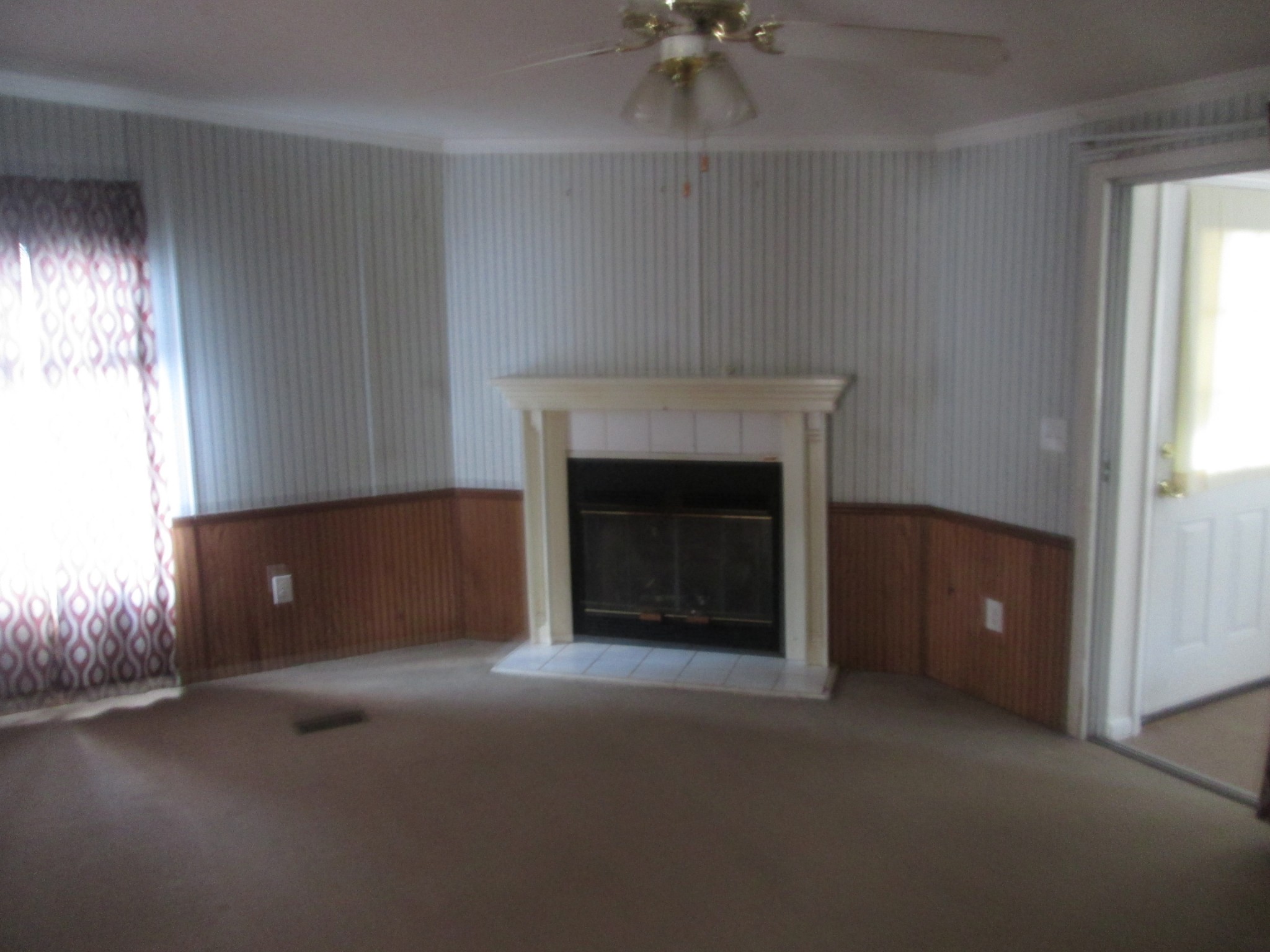 321 Manzano Road Madison, TN 37115 - Photo 4 of 16 an empty room with a fireplace and chandelier fan