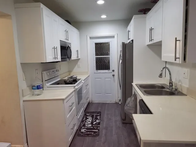 a kitchen that has a sink and a stove in it