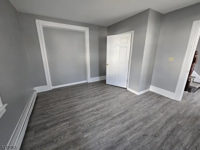 an empty room with wooden floor and closet