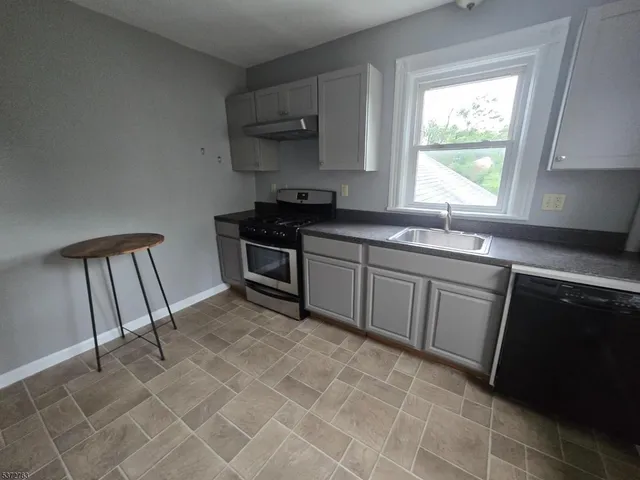 a kitchen with stainless steel appliances a sink stove and cabinets