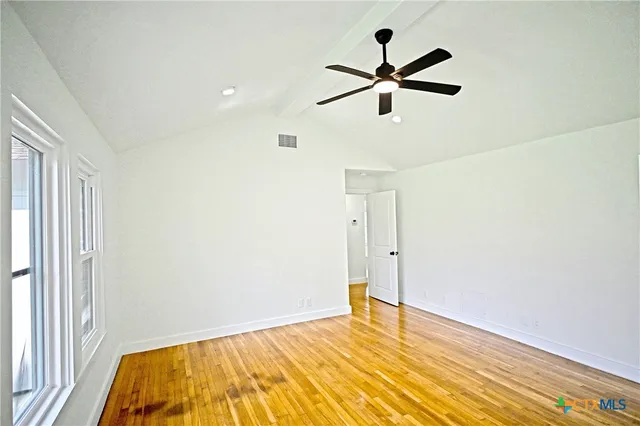 a view of empty room with wooden floor