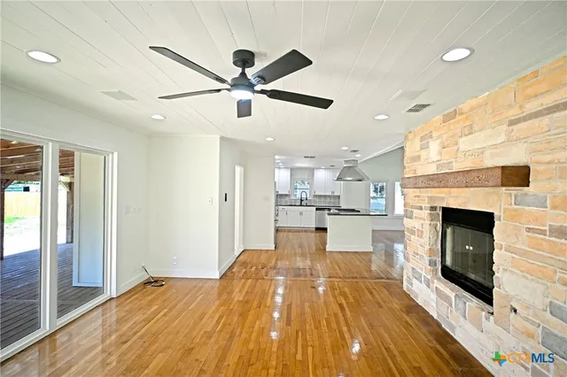 a view of a kitchen with a fireplace and wooden floor