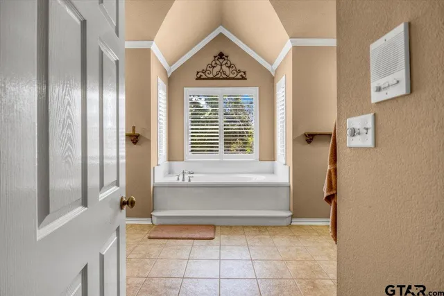 a spacious bathroom with a tub sink and mirror