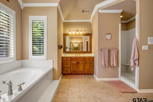 a spacious en suite bathroom with a granite countertop tub and a large mirror