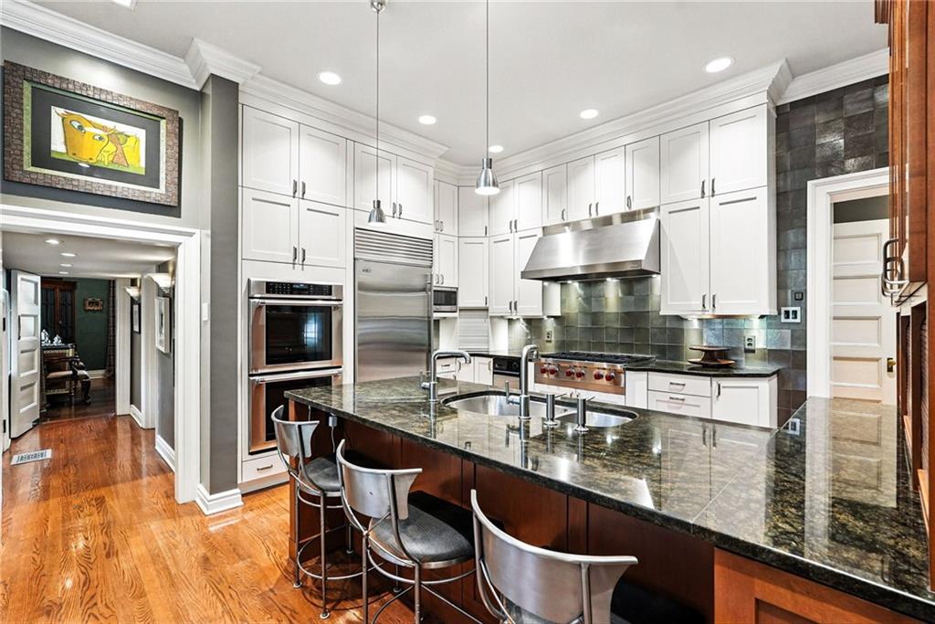 400 Devonshire Street Pittsburgh, PA 15213 - Photo 15 of 49 a kitchen with kitchen island a counter top space a sink stainless steel appliances and cabinets