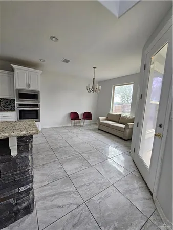 a large kitchen with kitchen island stainless steel appliances a stove a sink and a refrigerator