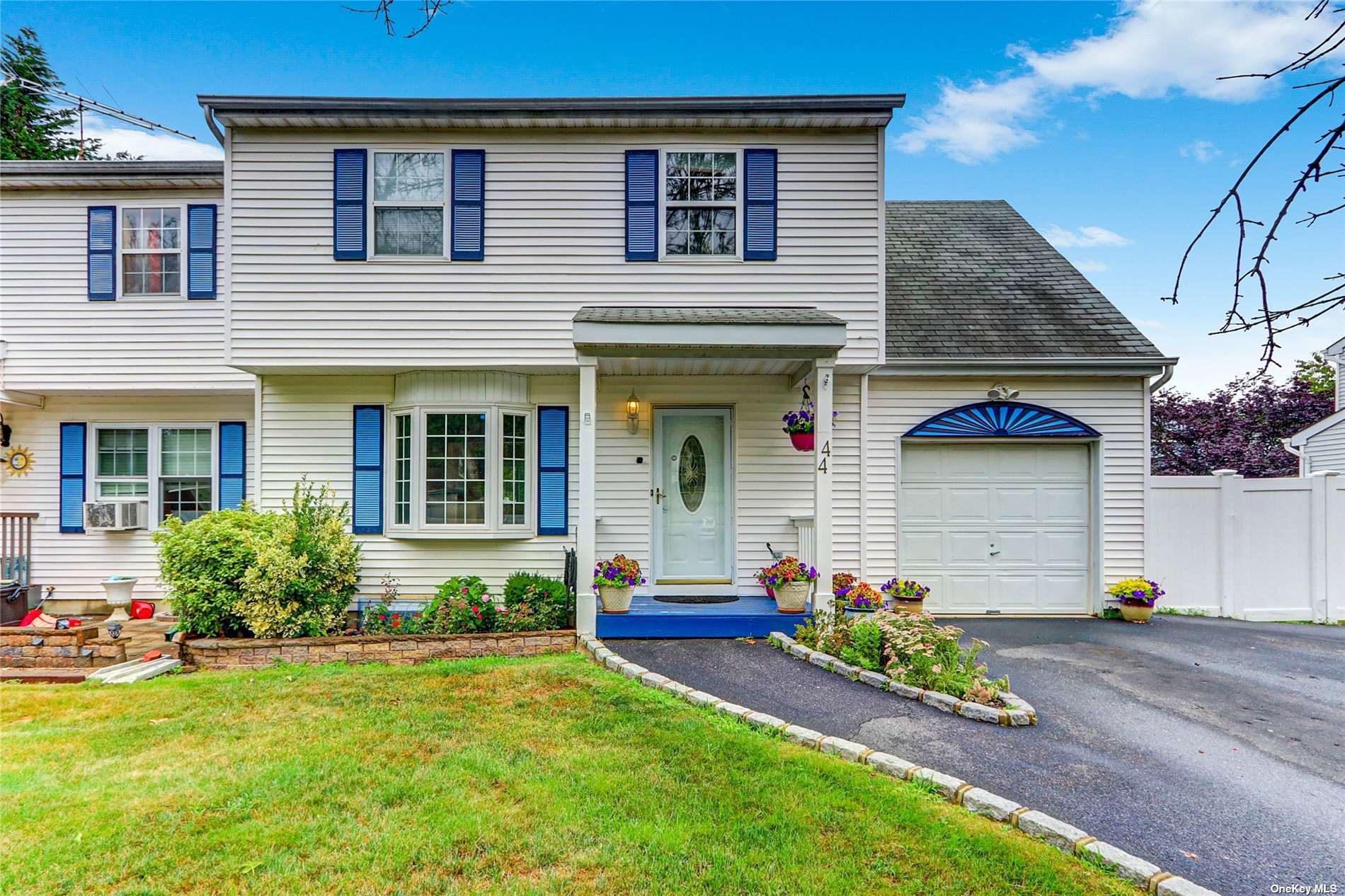 a front view of a house with a garden and plants