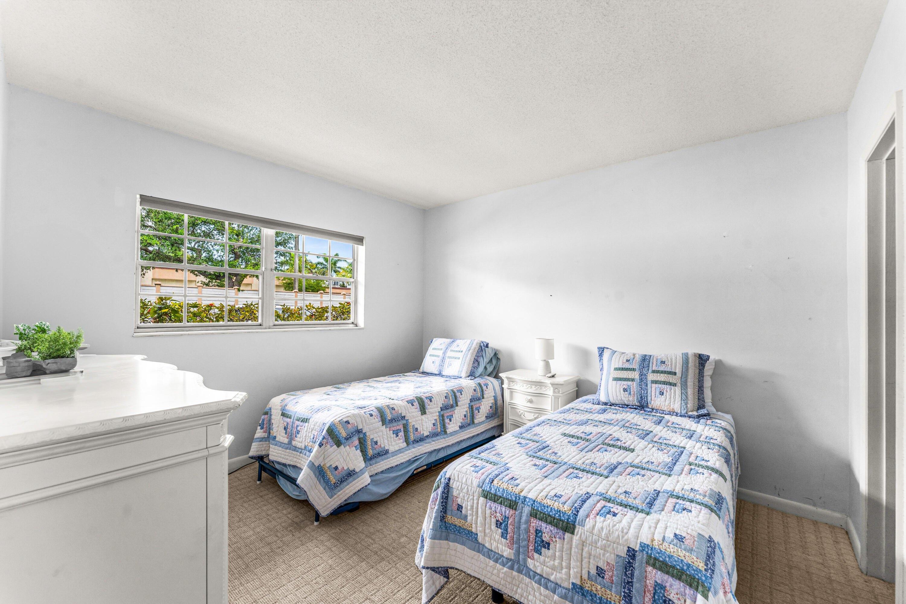 1951 Northeast 39th Street, Unit 131 Lighthouse Point, FL 33064 - Photo 15 of 31 a bedroom with two beds and a painting on the wall