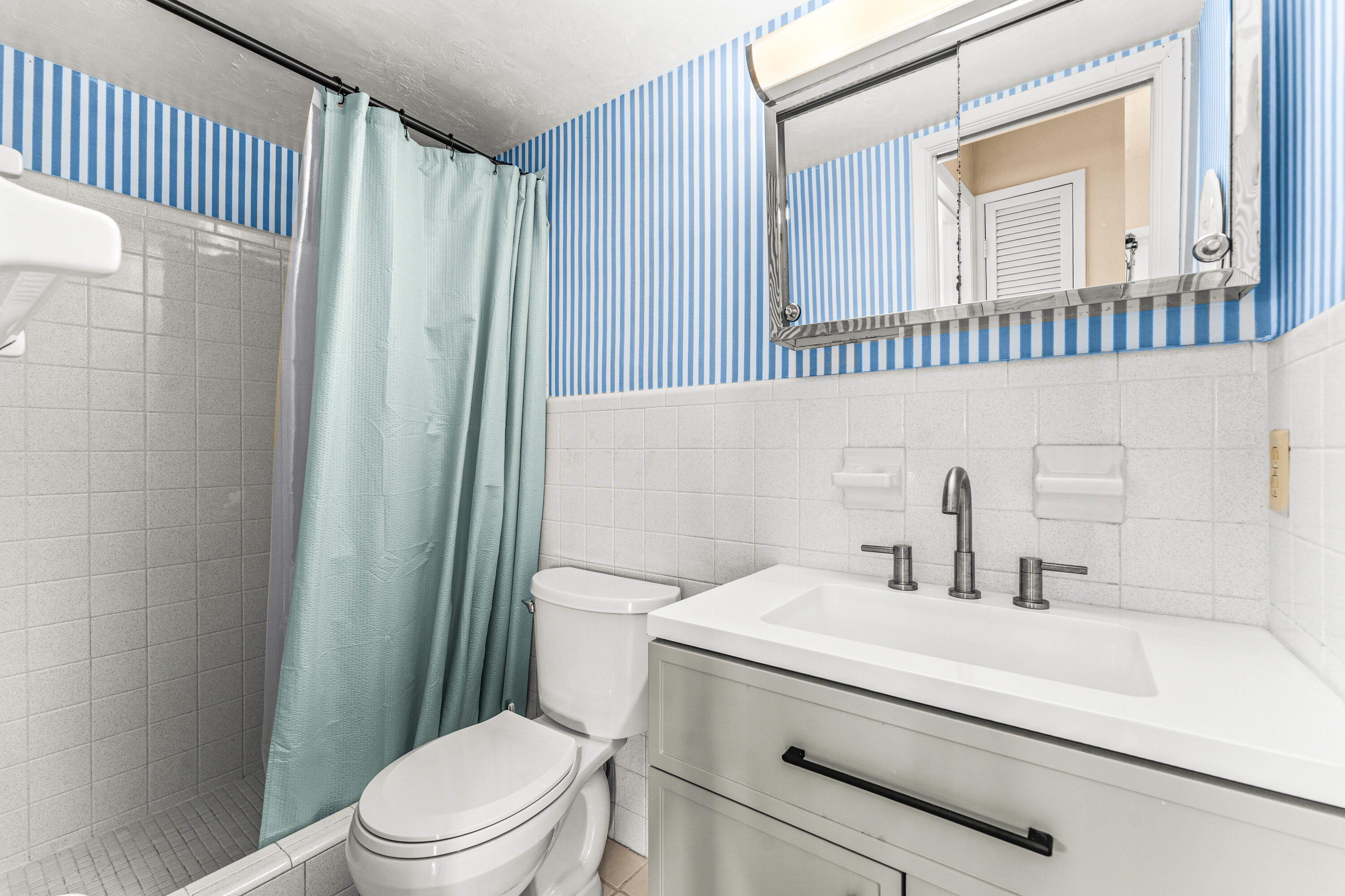 1951 Northeast 39th Street, Unit 131 Lighthouse Point, FL 33064 - Photo 16 of 31 a bathroom with a sink a toilet and shower