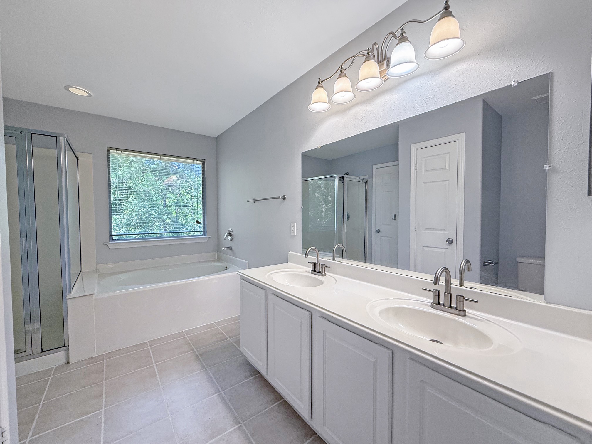 3 Peach Ridge Place The Woodlands, TX 77382 - Photo 14 of 22 a bathroom with a tub a sink and mirror