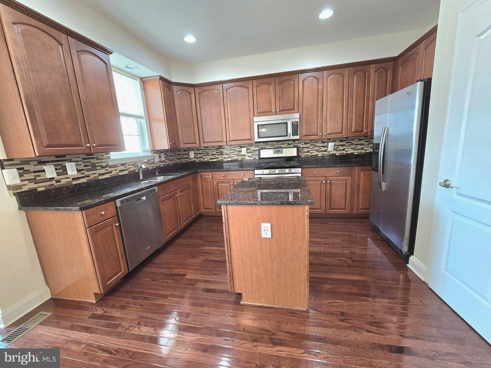 23012 Meadow Mist Road Clarksburg, MD 20871 - Photo 5 of 19 a kitchen with stainless steel appliances granite countertop a stove a sink dishwasher a refrigerator and a stove with wooden floors