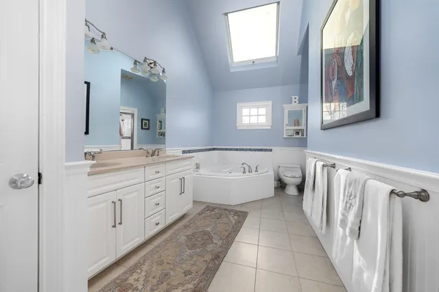 a spacious bathroom with a bathtub sink and mirror