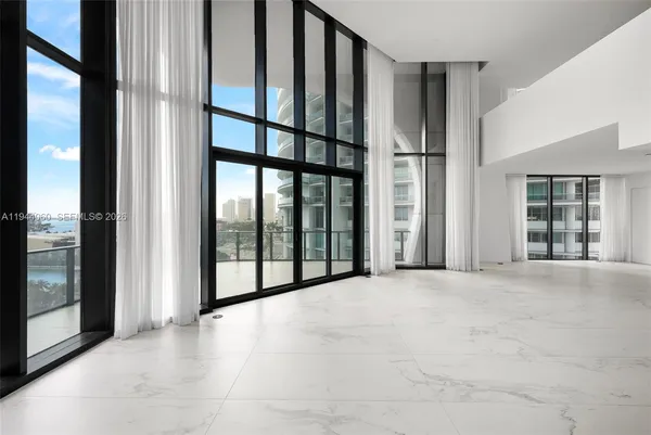 a view of an empty room with balcony and window