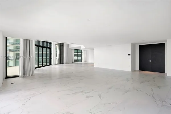 a large room with a large bed and kitchen view