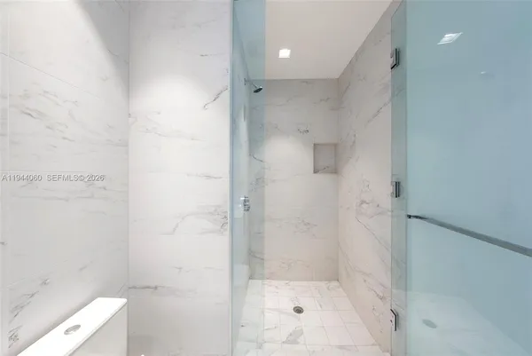 a bathroom with a white tub shower and toilet