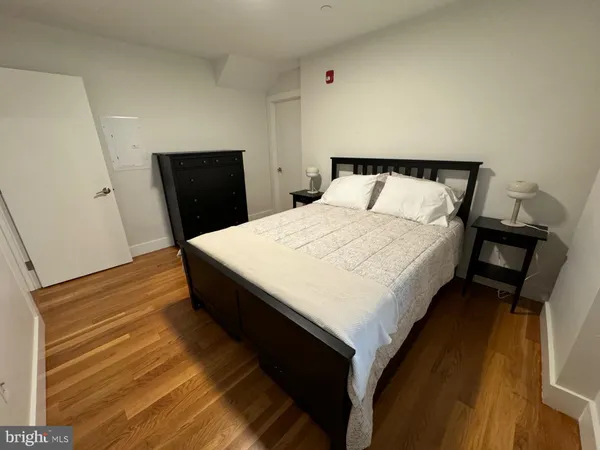 a bed sitting in a bedroom and wooden floor
