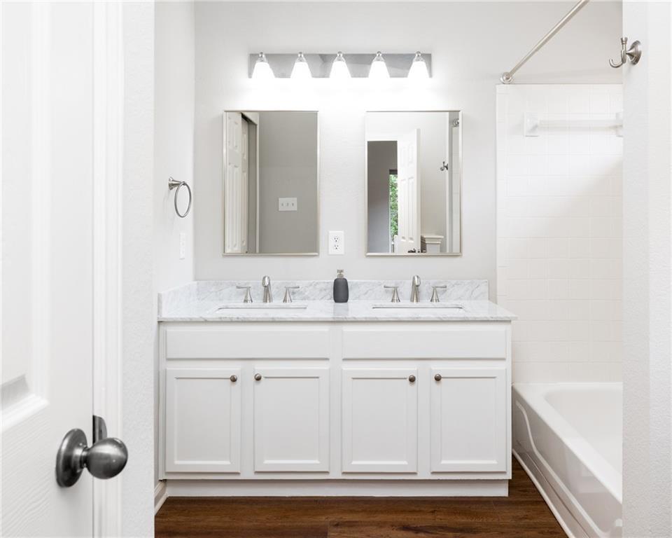 4526 Corran Ferry Loop Austin, TX 78749 - Photo 17 of 25 Clean lines define a functional bathroom space featuring dual sinks and stone countertops.