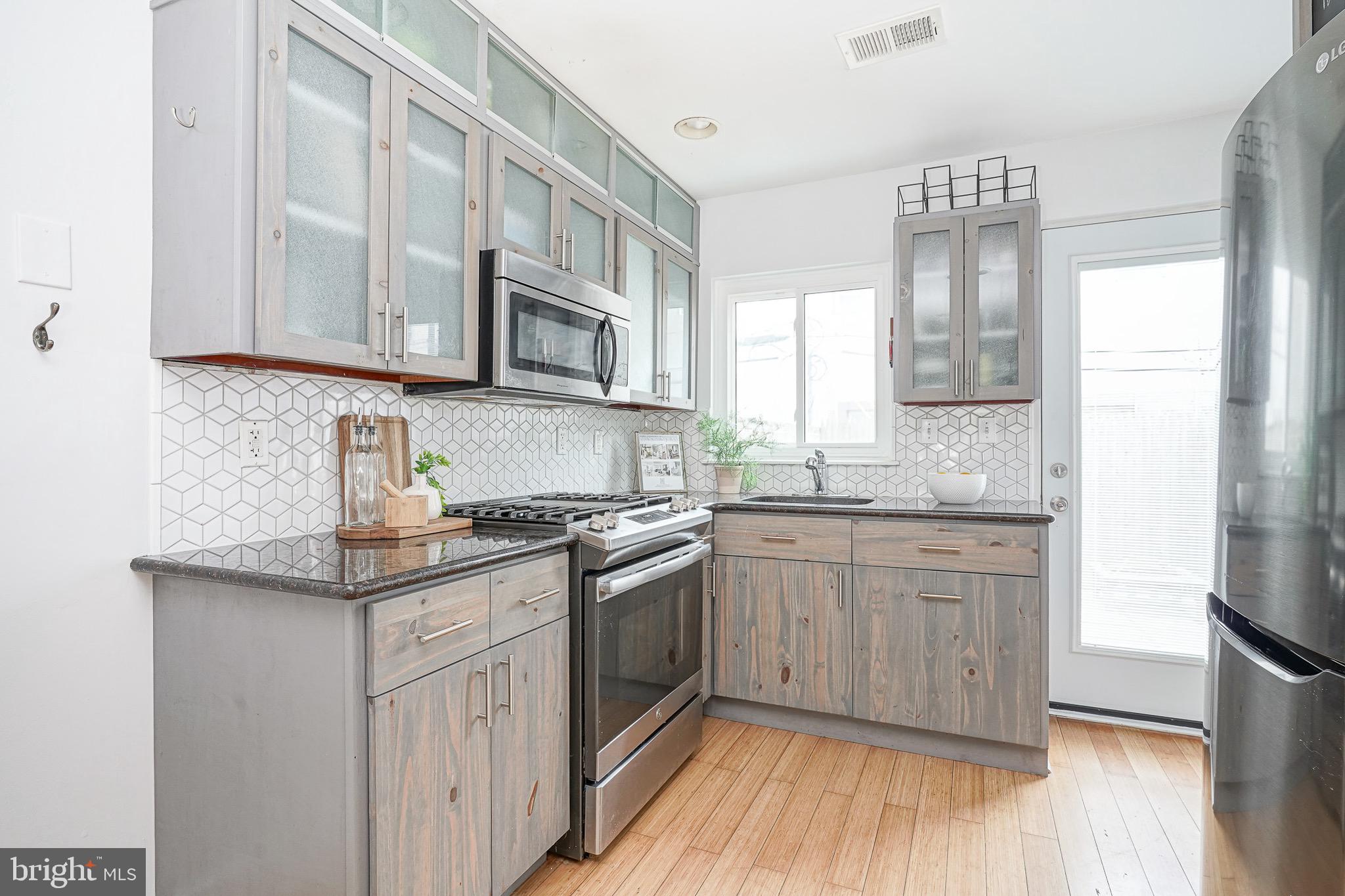 2111 Manton Street Philadelphia, PA 19146 - Photo 7 of 37 a kitchen with stainless steel appliances granite countertop a stove a sink and a microwave