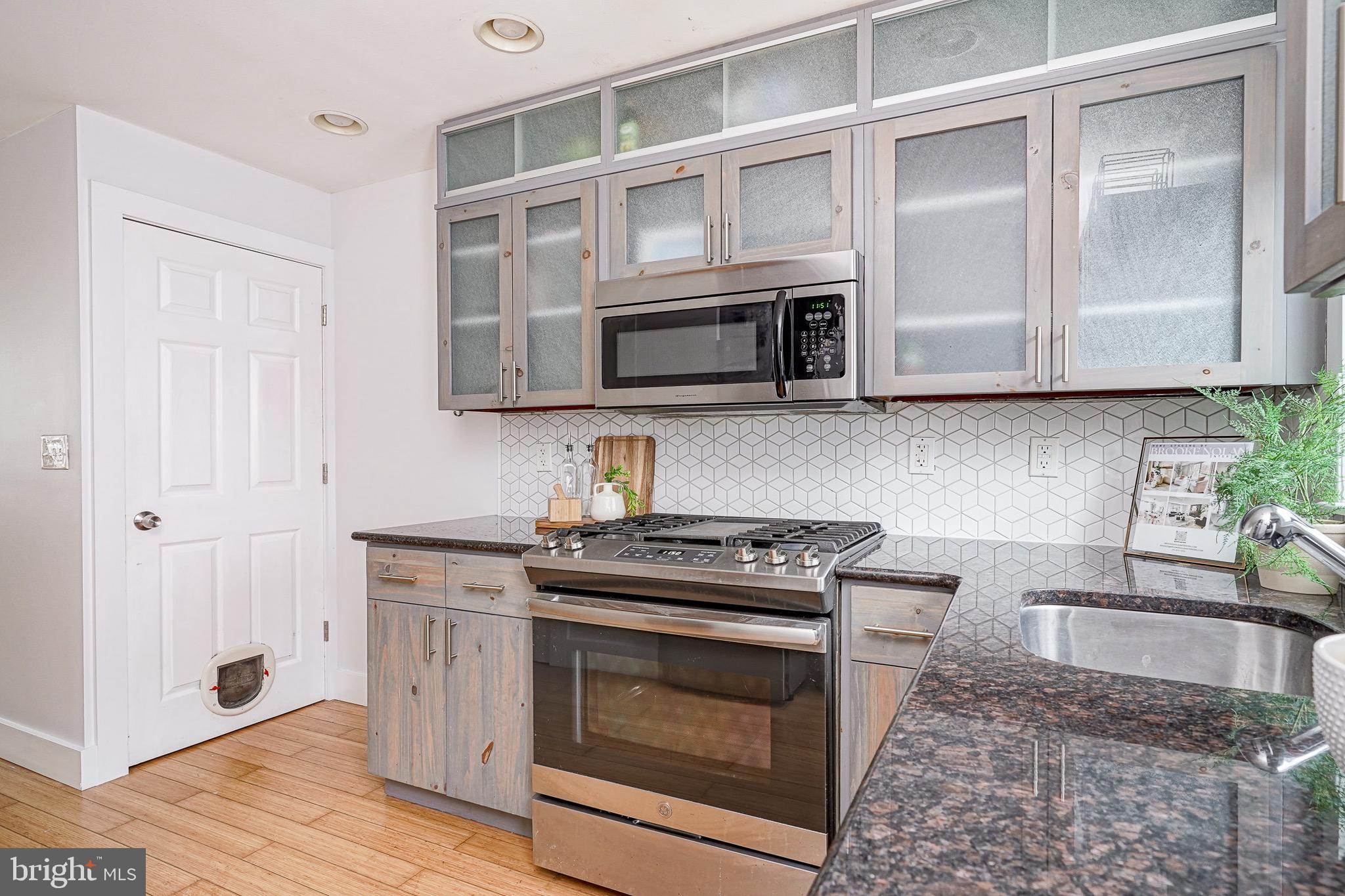 2111 Manton Street Philadelphia, PA 19146 - Photo 10 of 37 a kitchen with stainless steel appliances granite countertop a stove microwave and cabinets