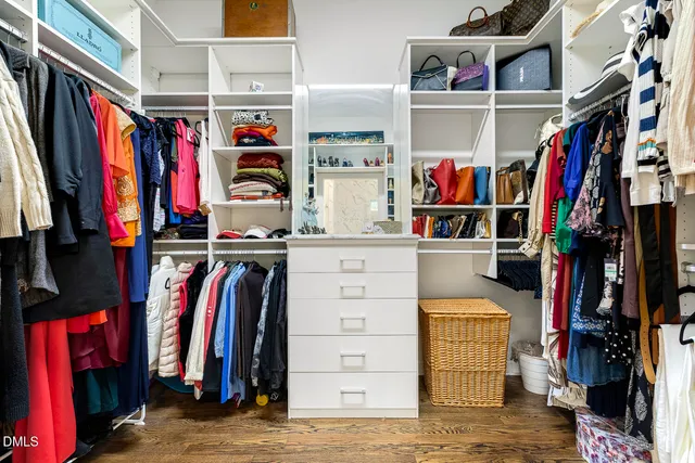a view of walk in closet with clothes and shoes