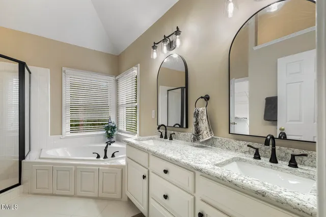 a bathroom with a granite countertop sink a mirror and a bathtub