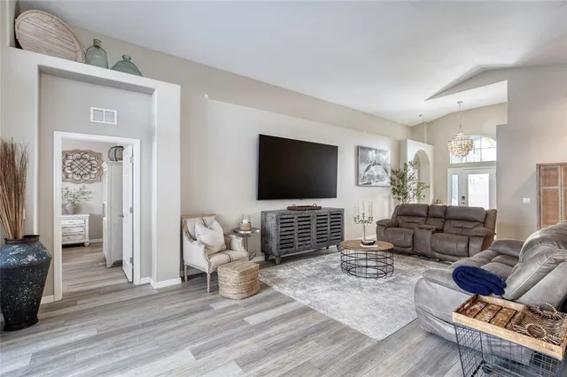 a open dining room with kitchen island furniture a wooden floor and a sink