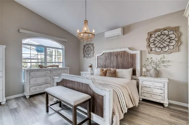 a bedroom with a bed chandelier and a window