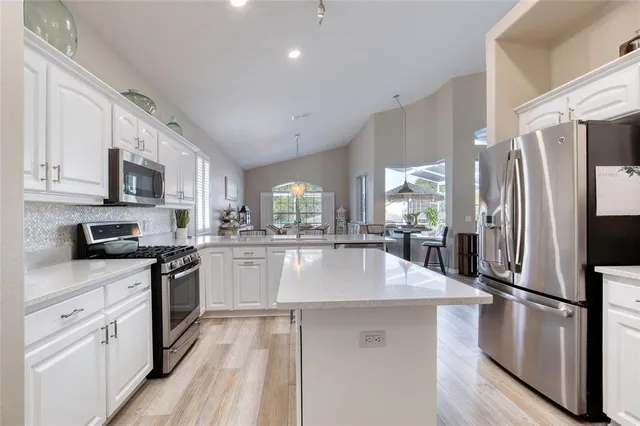 a view of kitchen with sink refrigerator dining table and chairs
