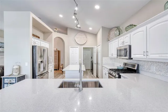 a living room with furniture a flat screen tv and kitchen view