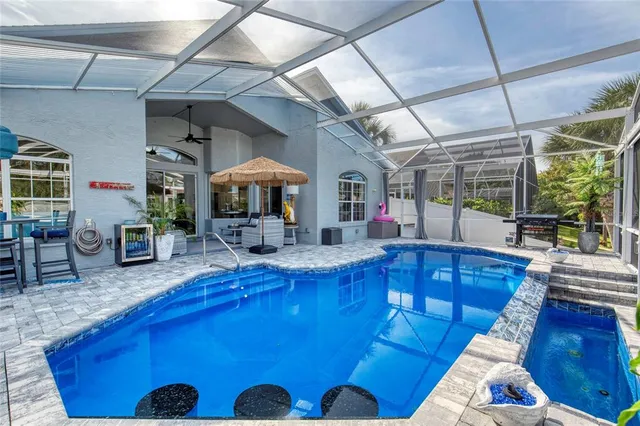 a view of a chairs and table in the patio next to a yard