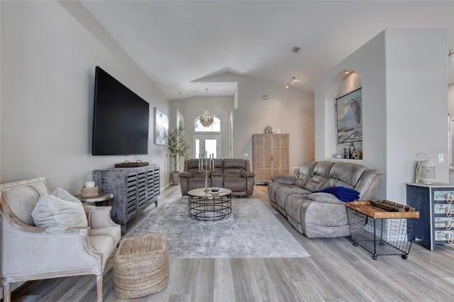 a living room with furniture and a dining table with kitchen view