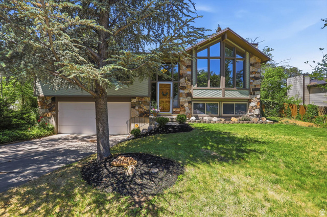 8938 Manchester Lane Sandy, UT 84093 - Photo 2 of 50 Stone and siding exterior with a prominent two-story window feature