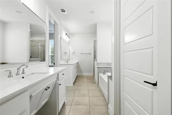 a spacious bathroom with a double vanity sink and mirror