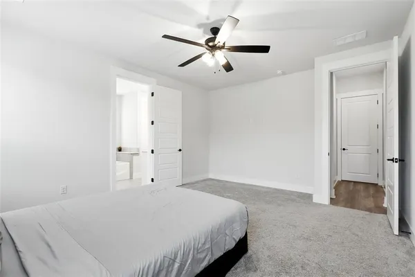 a spacious bedroom with a bed and a ceiling fan